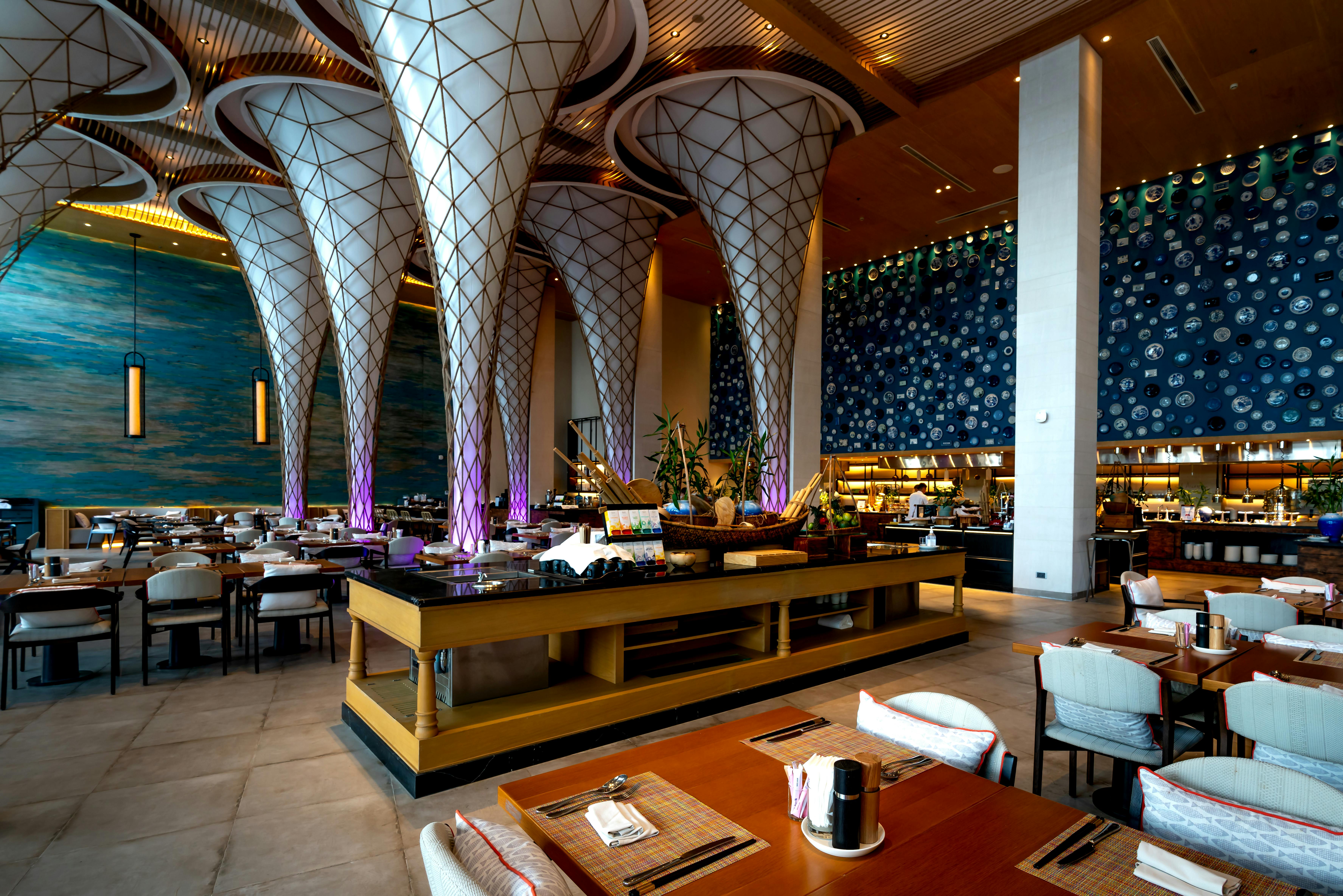 Výrazný interiér restaurace s art-deco sloupy a sofistikovaným osvětlením